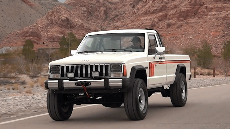 A 1987 Jeep Comanche driving on country road
