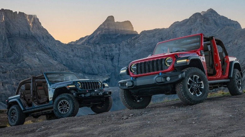 A red and black 2025 Jeep Wrangler parked by each other on a hill