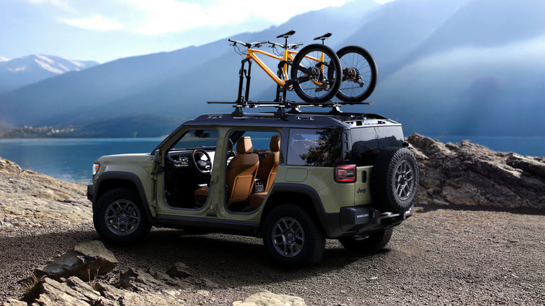 Rear 3/4 view of a green Jeep Recon with the doors off and bicycles on the roof