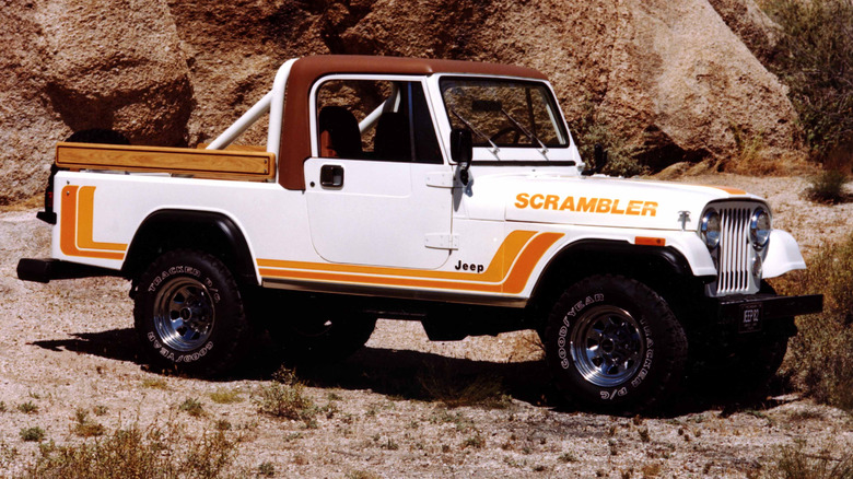 White 1982 Jeep CJ-8 Scrambler pickup truck left front view seen parked in a desert