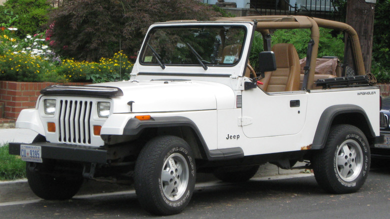 White Jeep Wrangler YJ left front view parked on a city street