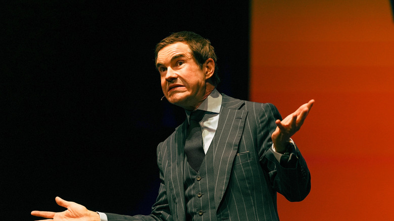 Jimmy Carr with a confused expression on stage.