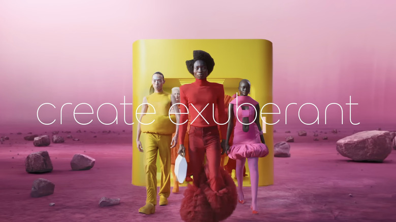 models in colorful clothes walk through a pink alien landscape