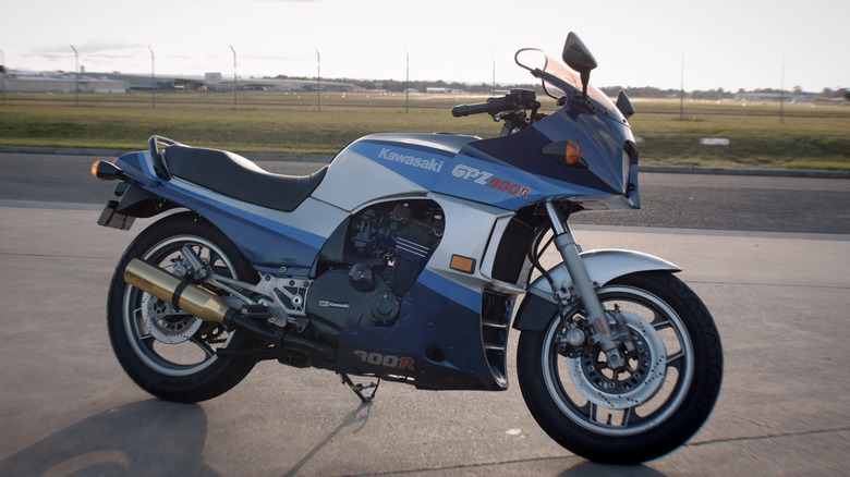 A classic blue and silver 1980s Kawasaki GPZ900R Ninja motorcycle parked on asphalt in side profile.