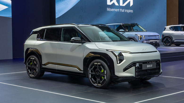 Front 3/4 view of a silver Kia EV3 GT at an auto show