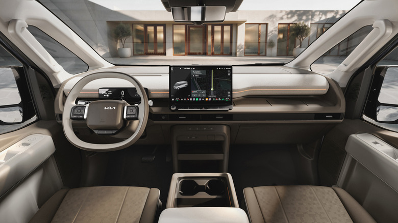 A wide shot of the dashboard in the passenger PV7 with brown seats and tan accents