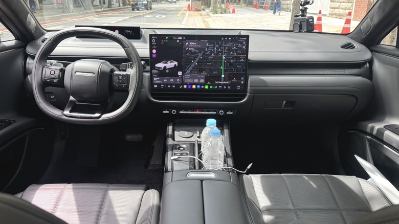 A wide shot of the dashboard in a Grandeur with a black interior with a road and caution cones visible out the windshield
