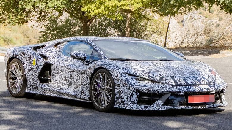 Front 3/4 view of a camouflaged Lamborghini Revuelto prototype
