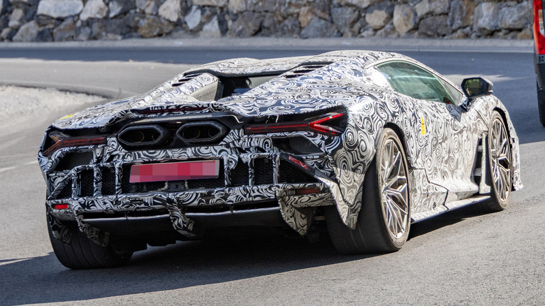 Rear 3/4 view of a camouflaged Lamborghini Revuelto