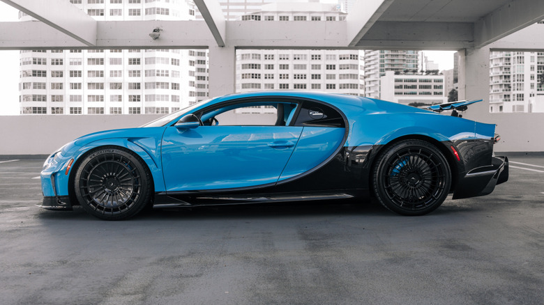 A side profile view of a black and blue Bugatti Chiron Super Sport 300+ on Michelin tires.
