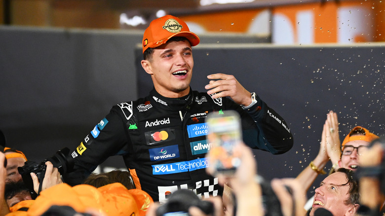 2025 F1 World Drivers Champion Lando Norris of Great Britain and McLaren celebrates with his team during the F1 Grand Prix of Abu Dhabi at Yas Marina Circuit on December 07, 2025 in Abu Dhabi, United Arab Emirates.