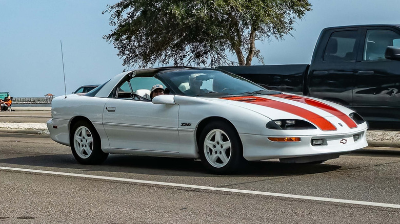 White and red 4th generation camaro with t-top on the road