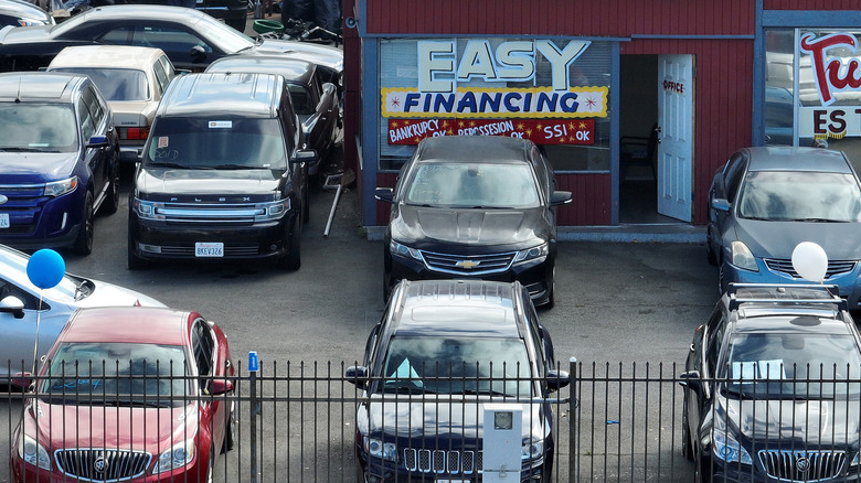 SAN PABLO, CALIFORNIA - SEPTEMBER 06: An advertisement of easy financing is posted on the front window of a used car lot on September 06, 2023 in San Pablo, California. Credit monitoring agencies are seeing a rise in defaults of credit card and auto loan payments as inflation continues to squeeze the pocketbooks of many Americans. According to credit agency Equifax, credit card delinquencies are at 3.8% default rate and car loans are at 3.6%. (Photo by Justin Sullivan/Getty Images)
