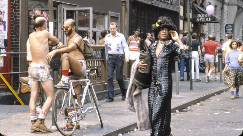 American gay liberation activist Marsha P Johnson (1945 - 1992) (center, in dark sequined outfit), along with unidentified others, on the corner of Christopher Street and 7th Avenue during the Pride March (later the LGBT Pride March), New York, New York, June 27, 1982. (Photo by Barbara Alper/Getty Images)