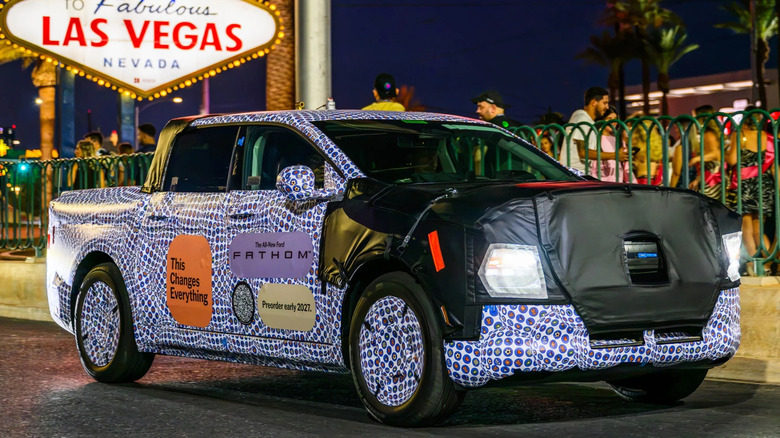 Front 3/4 view of a camouflaged Ford Fathom prototype driving in Las Vegas