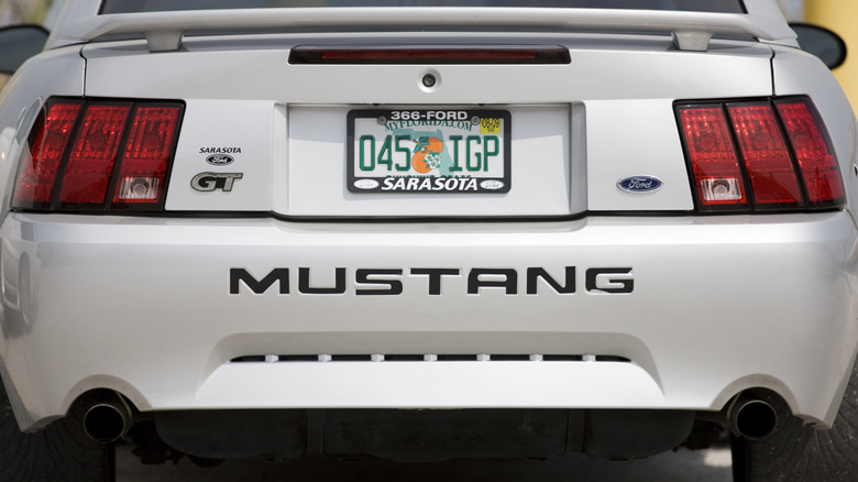 Rear view of a Ford Mustang GT with a dealer license plate cover blocking some lettering, which is now illegal