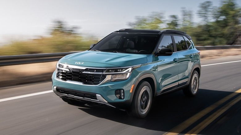 A Blue 2026 Kia Seltos driving down a road.