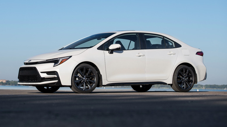 A white Toyota Corolla parked under a blue sky.