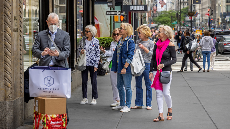 A group of elderly women window shopping outside a store