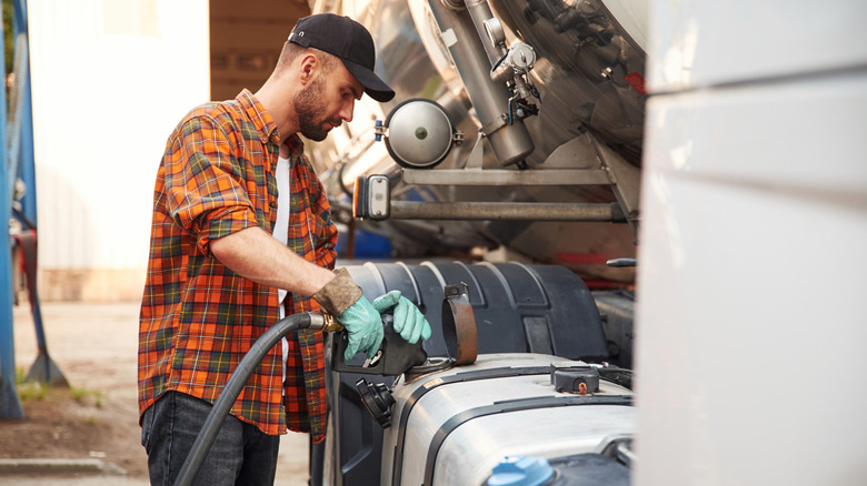 Man in plaid refueling semi truck