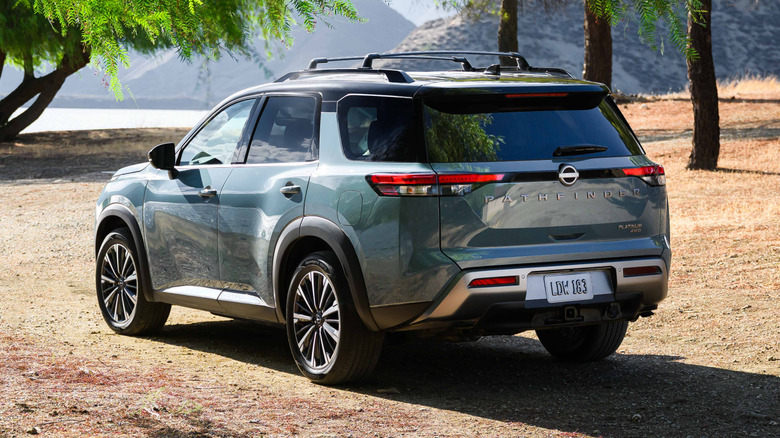 Rear three-quarters shot of the 2026 Pathfinder parkjed on drit in front of trees and a body of water