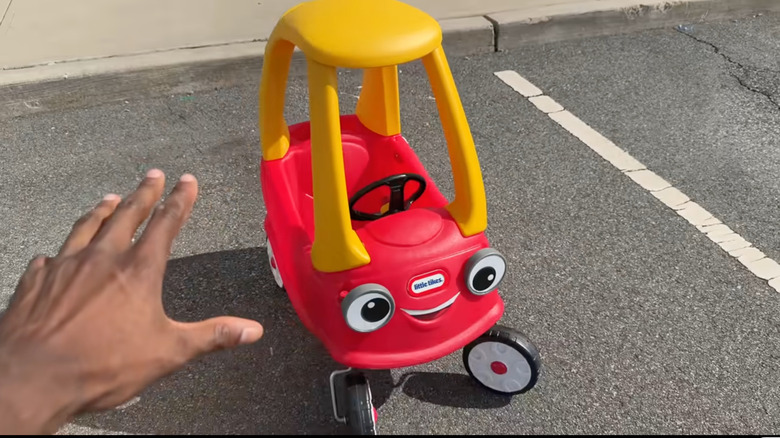 A screenshot showing a Cozy Coupe parked in a traditional parking spot