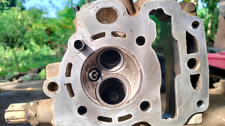 Close-up of a used metal engine cylinder block with a visible bore and machined surface