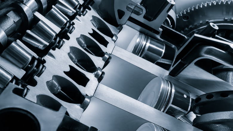 A close up of a car engine with the pistons and cylinders visible