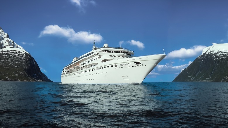 The Villa Vie Odyssey underway at sea between two mountains