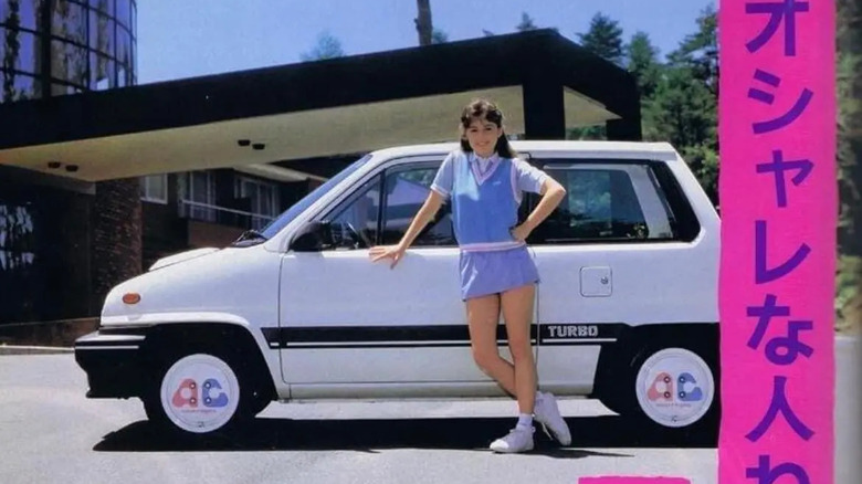 A photo of an old advertisement for these wheels showing a white Honda City Turbo with a woman in a blue dress standing in front of it