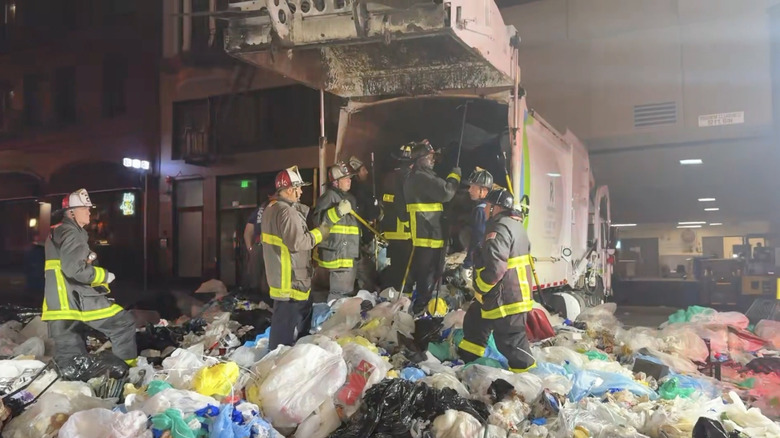 San Francisco Fire Department members freeing a man trapped in a garbage truck