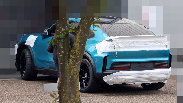 Rear 3/4 view of a partially camouflaged Porsche Cayenne Turbo GT Electric