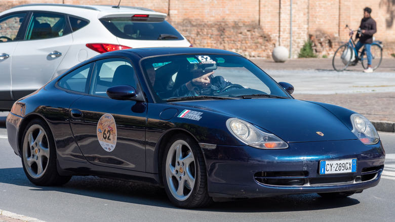 A 1999 Porsche 911 Carerra 996 with someone pointing inside