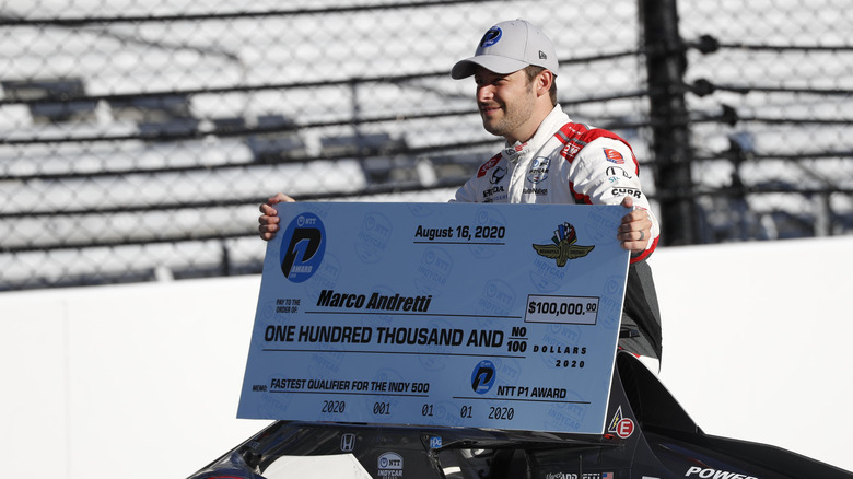Marco Andretti posing his oversized prize check after winning pole for the 2020 Indianapolis 500