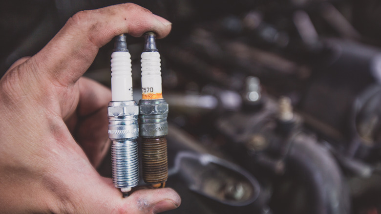 Comparing a new and rusty spark plug, with the rusty one certainly showing a lot of wear.