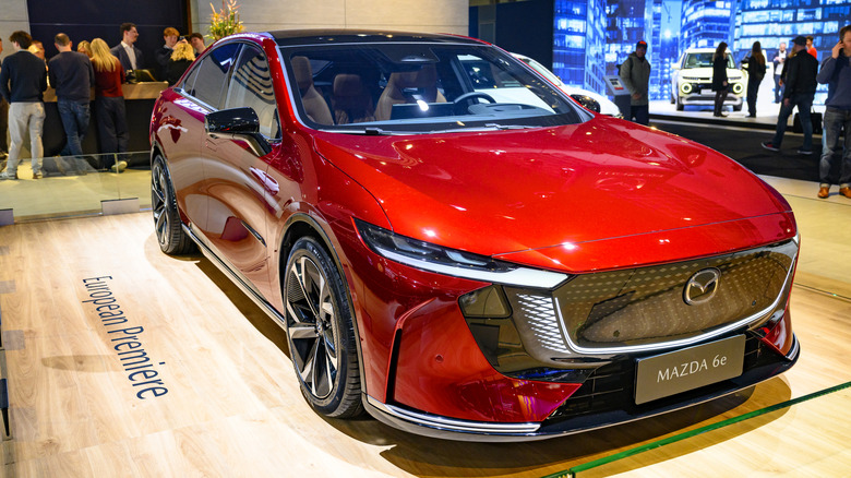 A reddish Mazda6 astatine a car arena pinch group successful nan backgtround