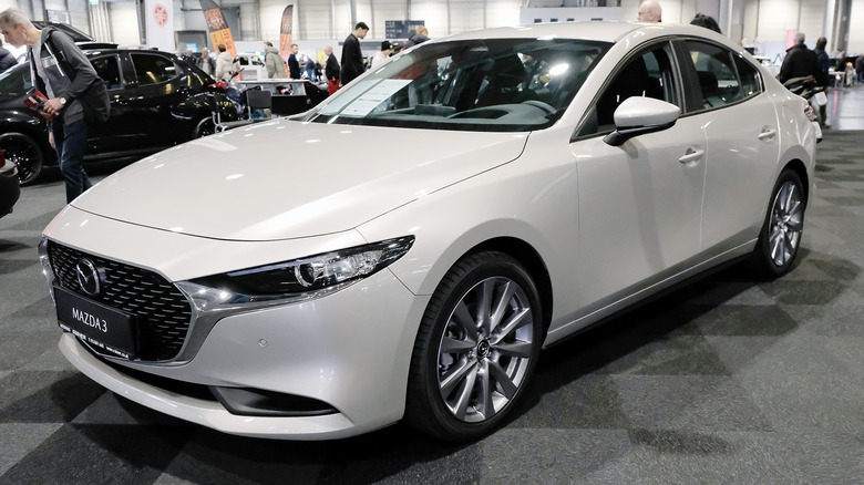 A achromatic Mazda3 astatine a car show