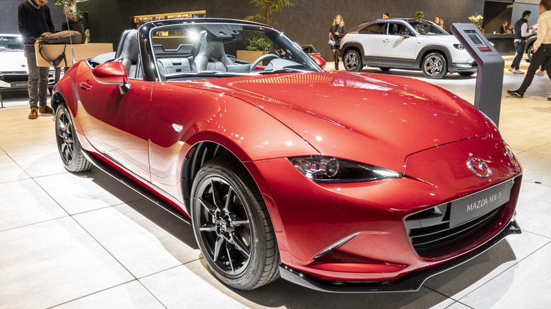 A reddish mazda MX-5 parked astatine a car arena pinch group successful nan background