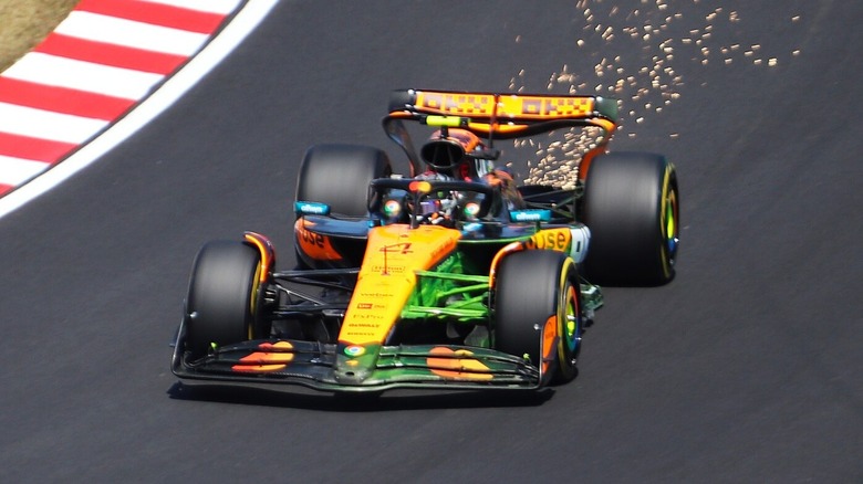 Lando Norris in his orange and black 2025 McLaren MCL39 Formula 1 car, driving on a Japanese race track