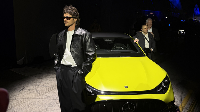 Jacob Elordi posing in front of a green Mercedes-AMG GT 4-Door Coupe