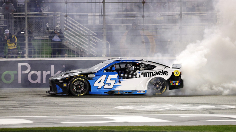 Tyler Reddick, driver of the #45 Pinnacle Toyota, celebrates with a burnout after winning the NASCAR Cup Series Autotrader 400 at Echo Park Speedway on February 22, 2026 in Hampton, Georgia.