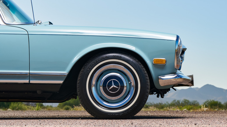 An old light blue Mercedes SL roadster on old Michelin radial tires.