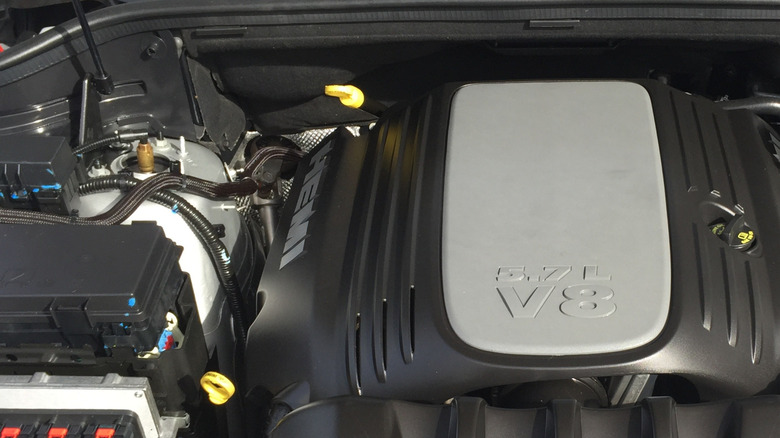 A plastic-covered 5.7-liter Gen-III Hemi V8 under the hood of a Jeep