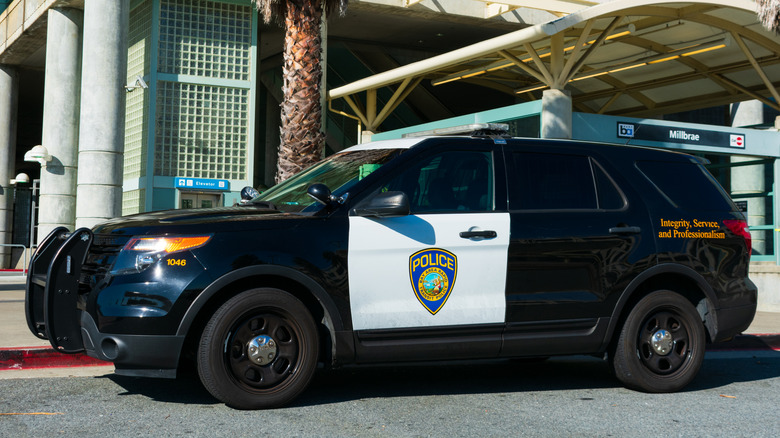 A Ford Police Interceptor Utility parked near an industrial building.