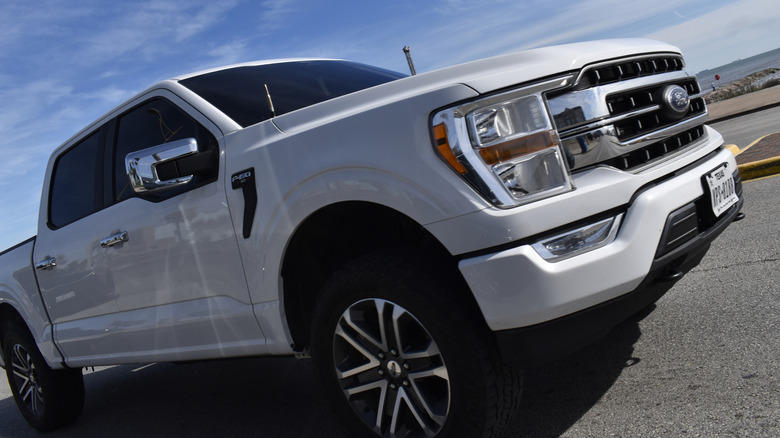 A white F-150 parked near some water.
