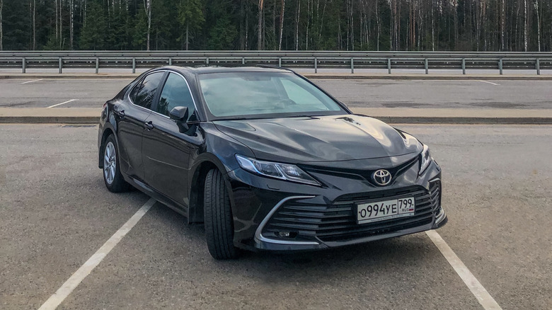 A dark Toyota Camry parked in a lot.
