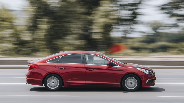 A red Hyundai Sonata cruising on a highway