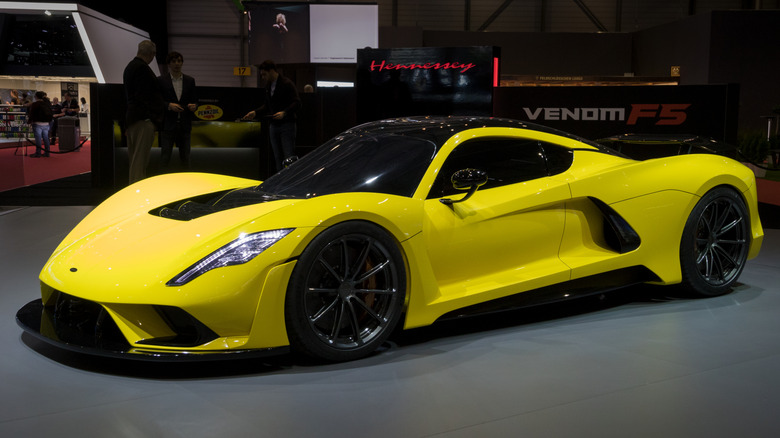 A yellow Hennessey Venom F5 on a display stand at the Geneva Motor Show.