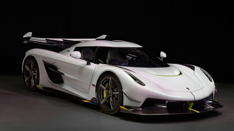 A white Koenigsegg Jesko on display in a dark and empty room.