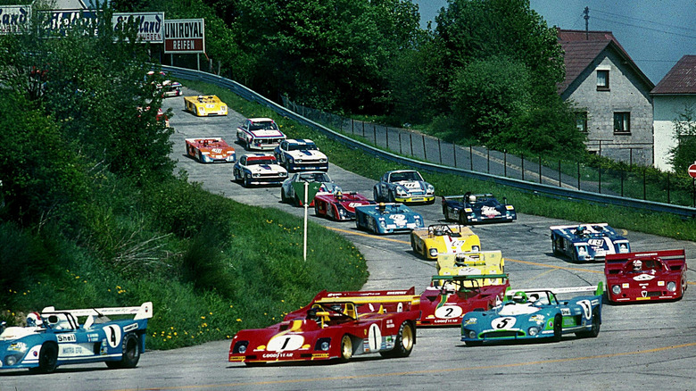 Race cars of mixed classes seen rounding a downhill curve toward the camera at Nürburgring in 1973